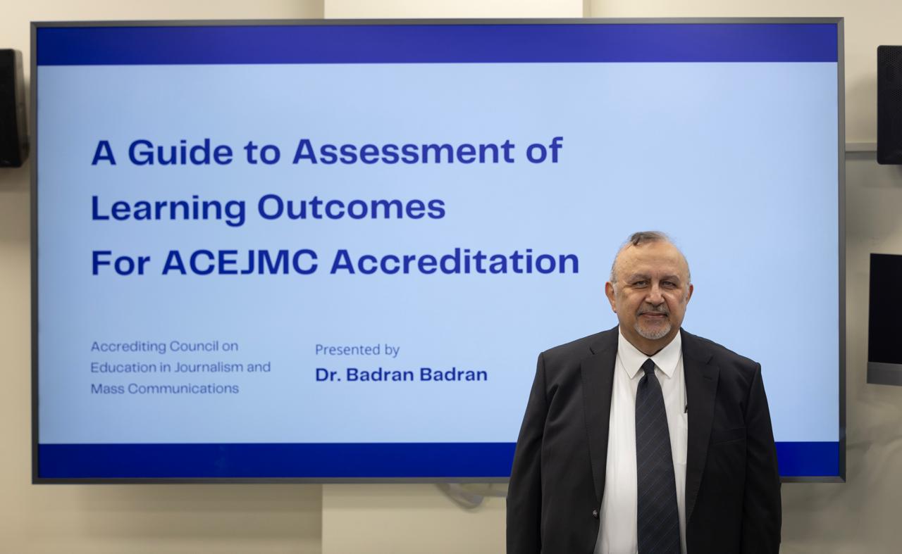Professor Badran A. Badran beside a screen showing his presentation, A Guide to Assessment of Learning Outcomes for ACEJMC Accreditation