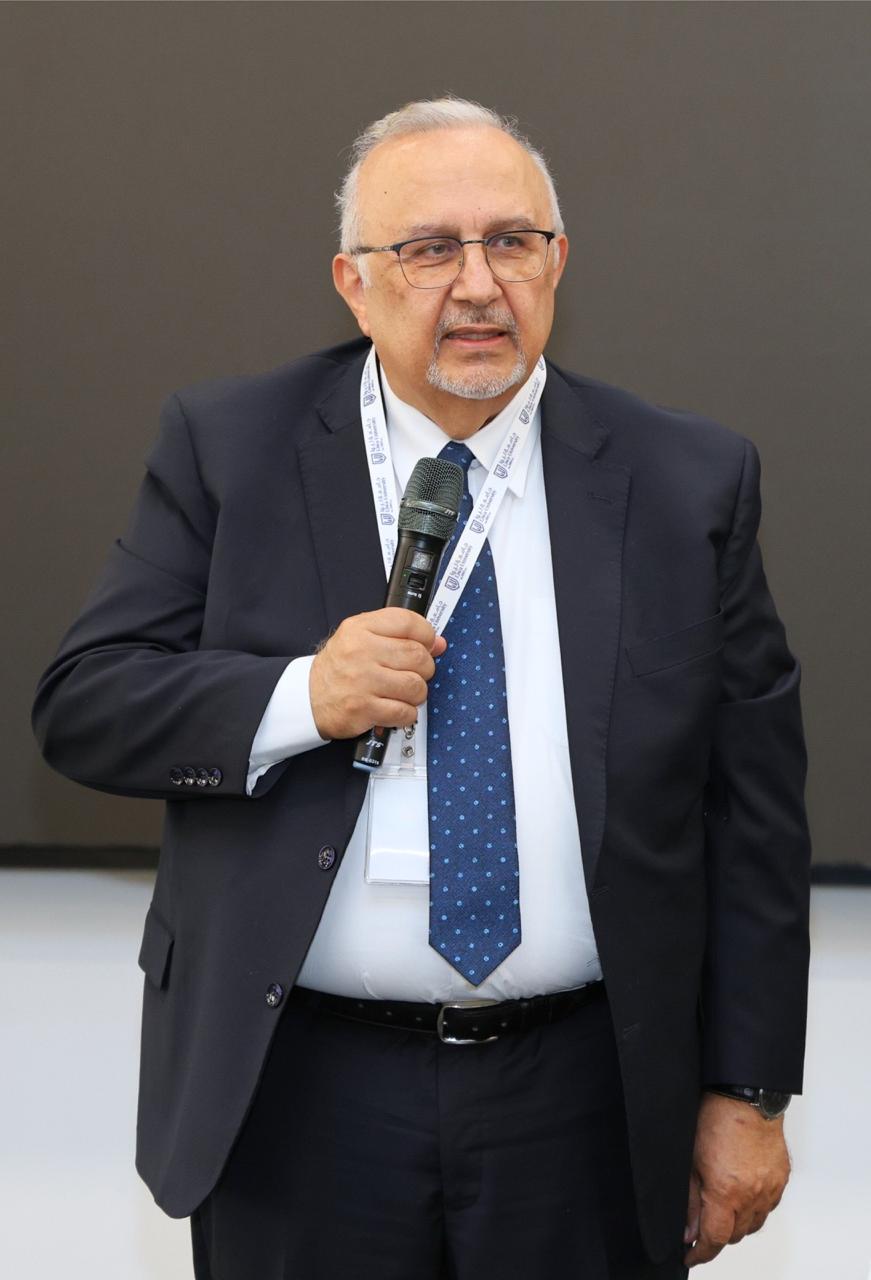 Professor Badran A. Badran speaking with a microphone in hand